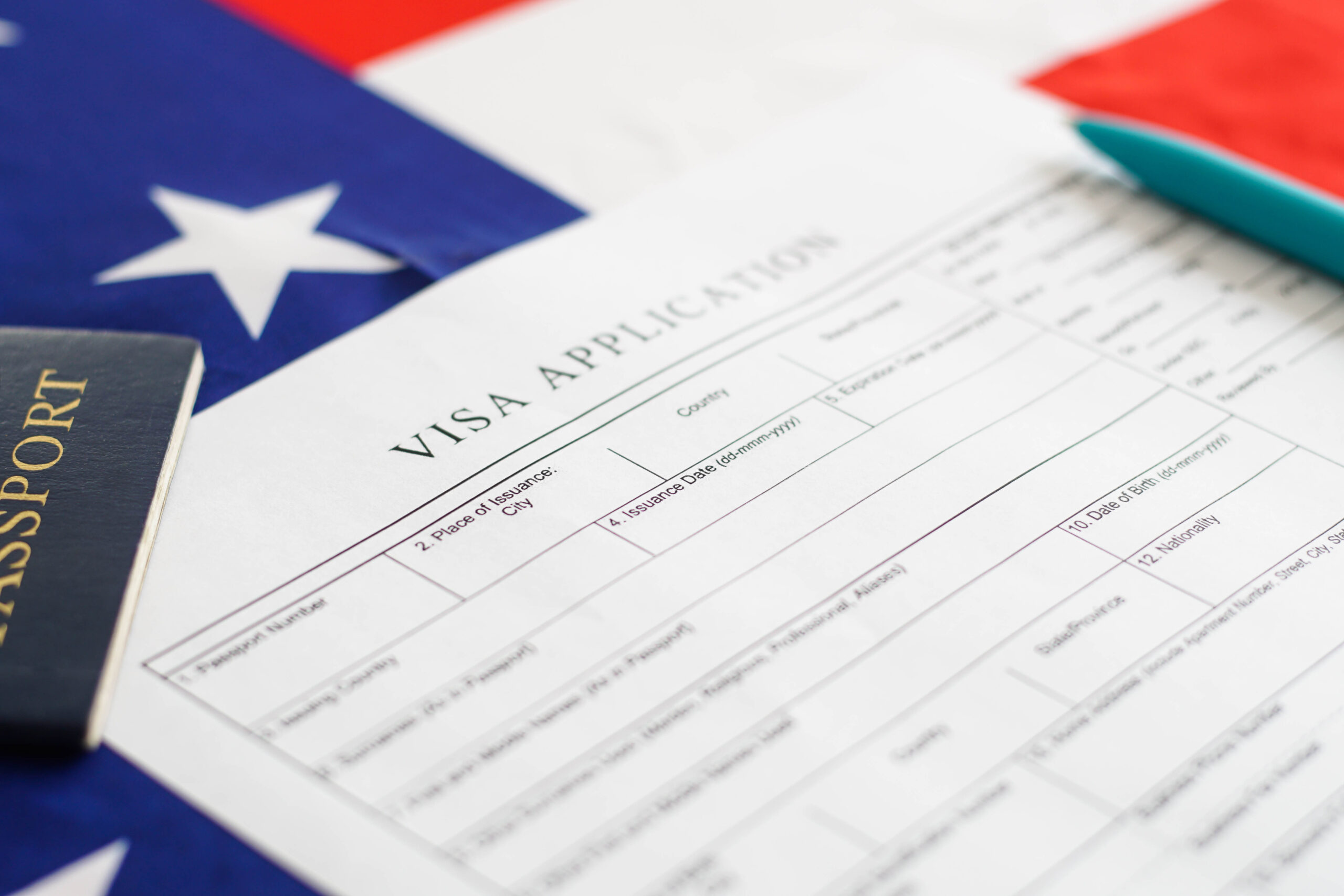 Person filling visa application form. American flag on the background. Immigration to USA.